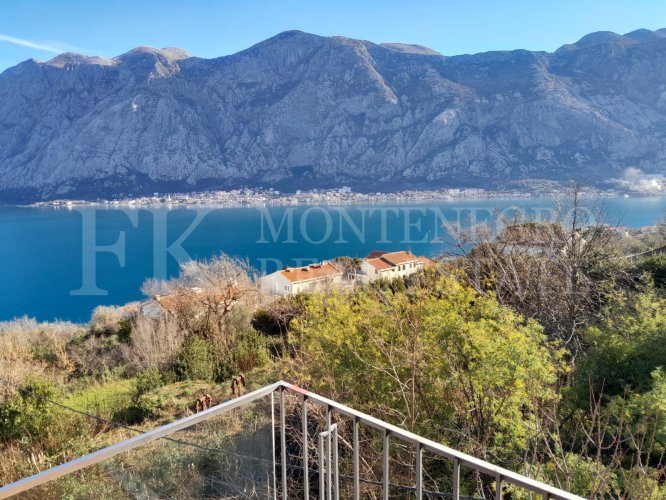 This newly built house with 143 sqm and an additional guesthouse (51 sqm) offers a prime location, just 330 meters from the coast, with an impressive panoramic view of the Bay of Kotor and the surrounding mountains.