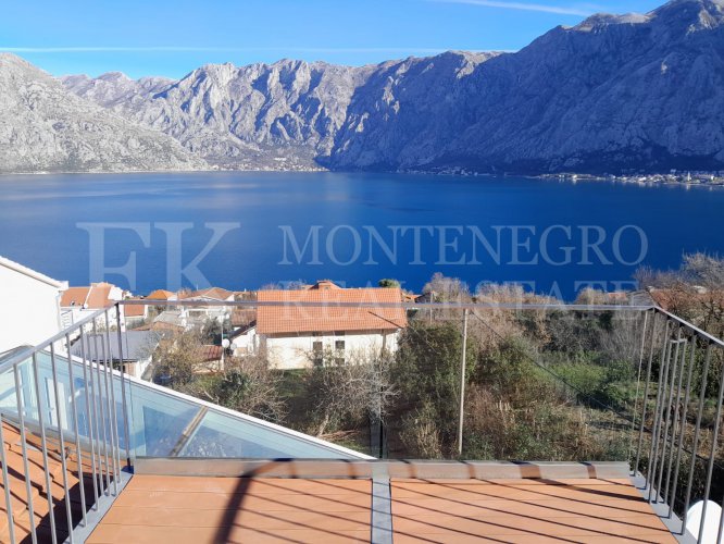 This newly built house with 143 sqm and an additional guesthouse (51 sqm) offers a prime location, just 330 meters from the coast, with an impressive panoramic view of the Bay of Kotor and the surrounding mountains.