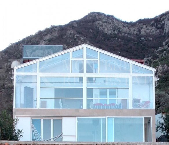 This newly built house with 143 sqm and an additional guesthouse (51 sqm) offers a prime location, just 330 meters from the coast, with an impressive panoramic view of the Bay of Kotor and the surrounding mountains.